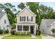 Tan two-story house with black shutters, a front porch, and landscaping at 1762 Bee Balm Rd, Johns Island, SC 29455