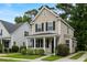 Tan two-story house with black shutters, a front porch, and landscaping at 1762 Bee Balm Rd, Johns Island, SC 29455