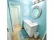 Clean bathroom with light blue walls and a round mirror at 209 Palmetto Blvd, Edisto Beach, SC 29438