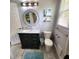 Bathroom features a marble-topped vanity, toilet, and a large round mirror at 209 Palmetto Blvd, Edisto Beach, SC 29438