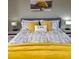 King-size bed with yellow blanket and patterned bedding in a serene bedroom at 209 Palmetto Blvd, Edisto Beach, SC 29438