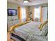 King-size bed with yellow blanket and patterned bedding in a serene bedroom with TV at 209 Palmetto Blvd, Edisto Beach, SC 29438