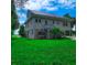Elevated beach house with green lawn and mature trees at 209 Palmetto Blvd, Edisto Beach, SC 29438