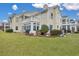 Back exterior of charming yellow home with landscaping and spacious yard at 2345 Tall Sail Dr # C, Charleston, SC 29414