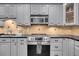 Stainless steel appliances and gray cabinets in this kitchen at 2371 Shipwatch Rd, Kiawah Island, SC 29455