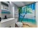 Clean bathroom with beach-themed shower curtain and white vanity at 251 Driftwood Ln # 251, Edisto Island, SC 29438