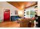 Living room with red door, comfy seating, and wood ceilings at 251 Driftwood Ln # 251, Edisto Island, SC 29438
