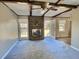 Spacious living room featuring a brick fireplace, wood beams, and access to the backyard at 303 Swamp Fox Ln, Goose Creek, SC 29445