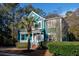 Charming two-story teal home with a welcoming front porch, tidy landscaping, and mature trees at 3100 Sonja Way, Mount Pleasant, SC 29466