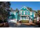 Two-story teal home with a white garage door, inviting front porch, and well-maintained lawn at 3100 Sonja Way, Mount Pleasant, SC 29466