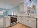Bright kitchen features white cabinets, stainless steel appliances, tile backsplash, and hardwood floors at 4329 Spur St, North Charleston, SC 29405