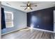Bright bedroom with blue and navy accent walls, ceiling fan, and hardwood floors at 109 Red Leaf Blvd, Moncks Corner, SC 29461