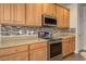 Kitchen with wood cabinets, granite counters, and tile backsplash at 109 Red Leaf Blvd, Moncks Corner, SC 29461