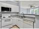 White kitchen with stainless steel appliances and granite countertops at 130 River Landing Dr # 7210, Daniel Island, SC 29492