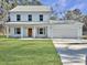 Two-story light blue house with a double garage and a manicured lawn at 1421 Brownswood Rd, Johns Island, SC 29455