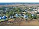 Aerial view of a waterfront community showcasing elegant homes nestled amongst trees at 1563 Headquarters Plantation Dr, Johns Island, SC 29455