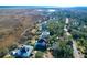 Aerial view of a waterfront community showcasing elegant homes nestled amongst trees at 1563 Headquarters Plantation Dr, Johns Island, SC 29455