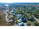 Aerial view of a waterfront community showcasing elegant homes nestled amongst trees at 1563 Headquarters Plantation Dr, Johns Island, SC 29455