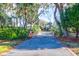 Long driveway leading to home with lush landscaping and brick border at 1563 Headquarters Plantation Dr, Johns Island, SC 29455