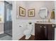 Stylish powder room with dark vanity, marble countertop, and frameless shower at 1563 Headquarters Plantation Dr, Johns Island, SC 29455