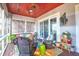 Relaxing screened porch with wicker furniture and colorful rug at 1563 Headquarters Plantation Dr, Johns Island, SC 29455