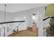 Upstairs hall with hardwood floors, white railings, and view to bedroom at 1563 Headquarters Plantation Dr, Johns Island, SC 29455