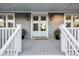 Inviting front porch with light gray flooring, white railings, and stylish lanterns at 1646 Red Tide Rd, Mount Pleasant, SC 29466