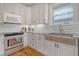 Modern kitchen featuring stainless steel sink, white cabinets, and hardwood floors at 209 Charleston Blvd, Isle of Palms, SC 29451
