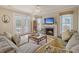 Spacious living room with fireplace, hardwood floors, and access to a deck at 209 Charleston Blvd, Isle of Palms, SC 29451