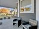 Covered porch with two wicker chairs and side table, offering a view of the street at 3002 Cross Vine Ln, Summerville, SC 29483