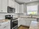 Modern kitchen with white cabinets, granite counters, and stainless steel appliances at 3002 Cross Vine Ln, Summerville, SC 29483