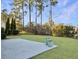 Large concrete patio in backyard, surrounded by grass and trees, with two decorative pots at 3002 Cross Vine Ln, Summerville, SC 29483