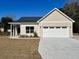 Tan house with a gray roof, a two-car garage, and a spacious front yard at 3012 Harvey Ave, North Charleston, SC 29405