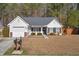 House exterior showcasing a white siding, gray roof, and a manicured lawn at 344 Slow Mill Dr, Goose Creek, SC 29445