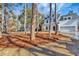 Two-story white house nestled among trees, showcasing curb appeal at 5294 Seewee Rd, Awendaw, SC 29429