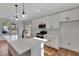 Modern kitchen featuring white cabinets, quartz countertops, and a large island at 5294 Seewee Rd, Awendaw, SC 29429