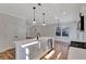 Modern kitchen with white cabinets, island, and farmhouse sink at 5294 Seewee Rd, Awendaw, SC 29429