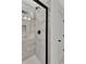 Modern shower with marble tile and black accents at 5294 Seewee Rd, Awendaw, SC 29429