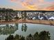 Aerial view of a waterfront community at sunset, showcasing numerous houses and a serene lake at 559 Tidewater Chase Ln, Summerville, SC 29486