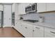 Modern kitchen with white cabinets, gas cooktop, and stainless steel appliances at 559 Tidewater Chase Ln, Summerville, SC 29486