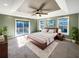 Large main bedroom with a tray ceiling, sliding glass doors to deck, and plush carpet at 7228 Mossy Creek Ln, Hanahan, SC 29410