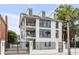 Three-story white house with black windows, balconies, and gated entry at 100 Murray Blvd, Charleston, SC 29401