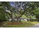 White brick ranch house with mature oak trees and manicured lawn at 1134 Mim Ave, Charleston, SC 29407