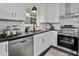 Modern kitchen with white cabinets, stainless steel appliances, and black countertops at 1134 Mim Ave, Charleston, SC 29407