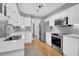 Modern kitchen with white cabinets, stainless steel appliances, and gray backsplash at 1449 Waterside Ct, Mount Pleasant, SC 29464