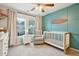 Charming Bedroom with a crib, rocking chair, and a soothing green accent wall at 1654 Sparkleberry Ln, Johns Island, SC 29455