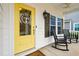 Inviting yellow front door with rocking chairs on porch at 1654 Sparkleberry Ln, Johns Island, SC 29455