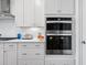 Modern double oven in stainless steel, built into white shaker cabinets at 2020 Parish House Cir, Johns Island, SC 29455