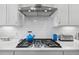 Stainless steel gas cooktop with white shaker cabinets and subway tile backsplash at 2020 Parish House Cir, Johns Island, SC 29455