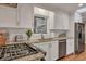 Updated kitchen boasts granite countertops, stainless steel appliances, and white cabinetry at 2216 S Dallerton Cir, Charleston, SC 29414